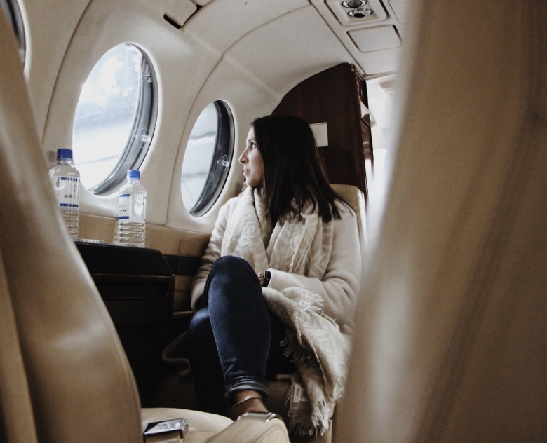 A woman looking outside the window of a King Air.