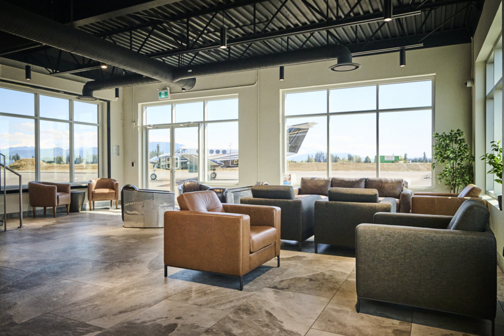Interior of the Fast Air YXX lobby with seating and aircraft visible.